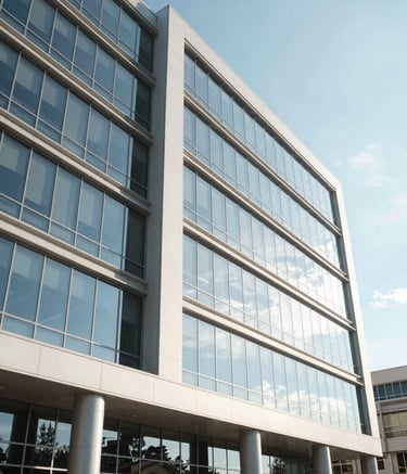A modern commercial office building in Spokane, Washington, under a bright North American sky, featuring sleek glass windows and a professional, streamlined architecture. The scene is bright and professional, utilizing light blue and off-white tones.