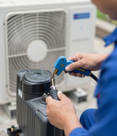Close-up shot of a technician's hands using professional tools to service an outdoor AC compressor unit. The lighting is crisp daylight, highlighting the technical proficiency and reliable nature of the service. Brand colors #4A6D8C and #8AA2B6 are visible in the equipment.