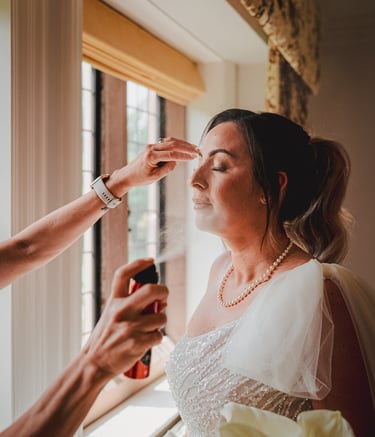 Bride having makeup applied in Leeds Airbnb – documentary wedding photography by The Wedding Edit