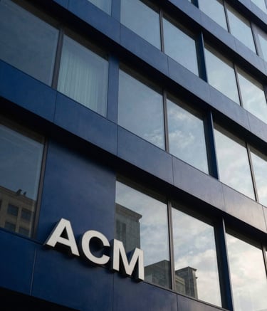 A close-up photograph of a modern ACM facade on a contemporary commercial building in a South American urban setting. The lighting is crisp afternoon sun, highlighting the clean, precise finish and deep navy blue panels. The composition is angled upwards to emphasize architectural scale.