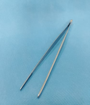Pinça anatômica sobre tecido azul estéril, usada para manuseio delicado de tecidos.