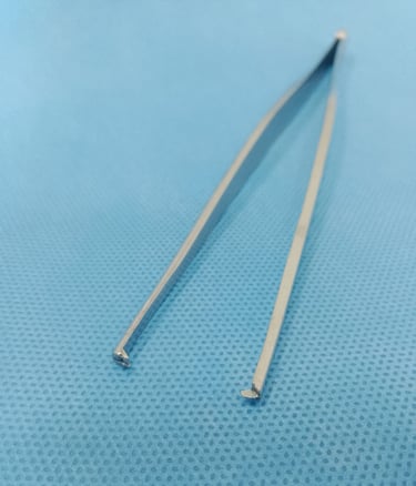 Pinça dente de rato sobre tecido azul estéril, usada para segurar tecidos firmes.