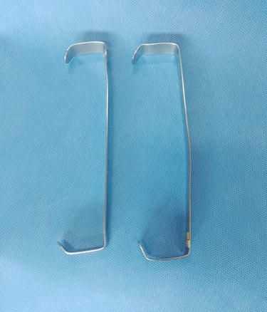 Afastador Farabeuf cirúrgico sobre tecido azul estéril, usado para afastar tecidos e melhorar a visu