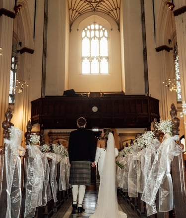 a bride and groom are standing in a church