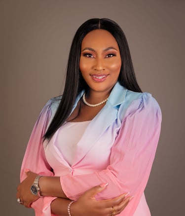 Professional portrait of a smiling woman wearing a pink and blue ombre blazer and pearl necklace.