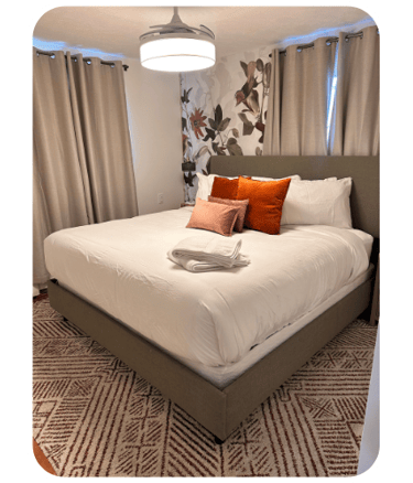 Freshly cleaned Airbnb bedroom with decorative floral wall by SparkEaseCleaning