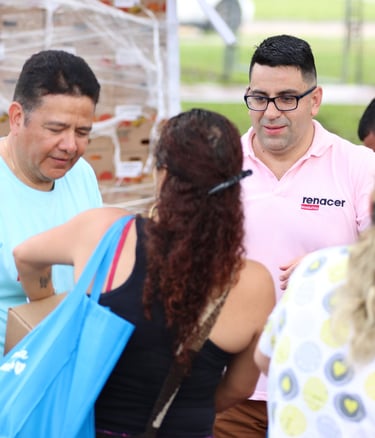Volunteers and community members distribute boxes of food during a humanitarian relief event.