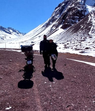 a man standing next to a motorcycle on a dirt road
