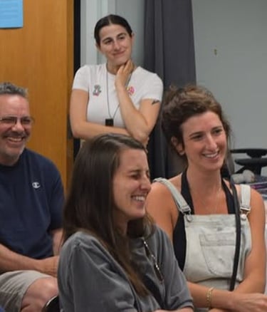 Diverse group of smiling colleagues enjoying a collaborative team meeting in a casual office setting.