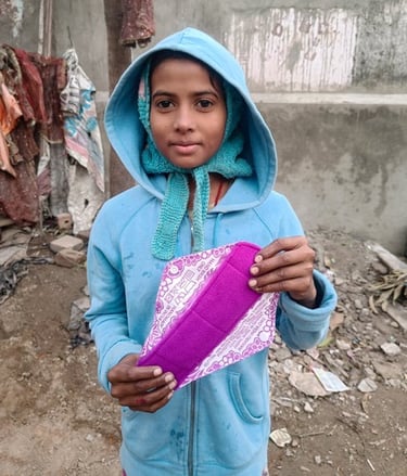 Young girl holding up a Hanaru reusable sanitary napkin