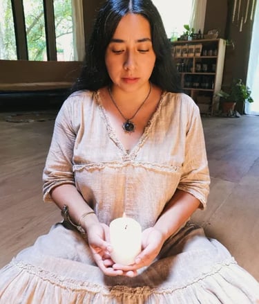 Mujer sentada sosteniendo una vela encendida