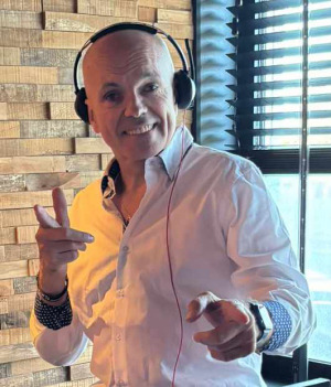 a man in a white shirt and headphones on a table