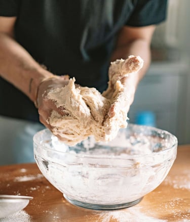 Corso di panificazione in mulino - mani che lavorano la pasta per viaggiatori over 60 amanti della t