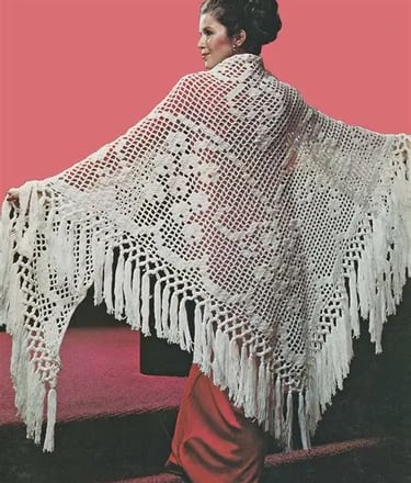 a woman in a white crochet shawl with fringes and red dress