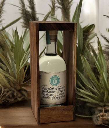 Botella de lu mezcal tepextate silvestre con fondo blanco y plantas de mezcal, botella caja madera