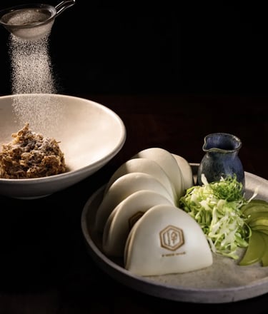 Exquisite bao buns with crispy filling, fresh greens, and sauce, served at Lucky Cat Bishopsgate