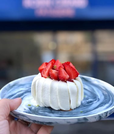 un délicieux fraisier dans une jolie assiette devant Robin Girard Pâtisserie