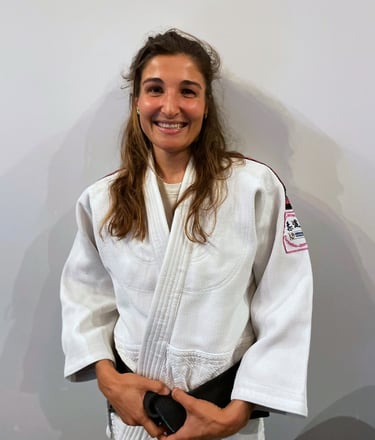 Une femme en kimono de Judo, portant une ceinture noire.