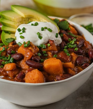 Bowl with vegan chili sin carne with beans, vegetables, vegan topping yogurt and avocado