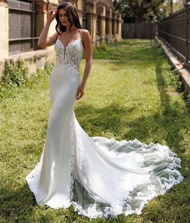 a woman in a white dress standing in the grass