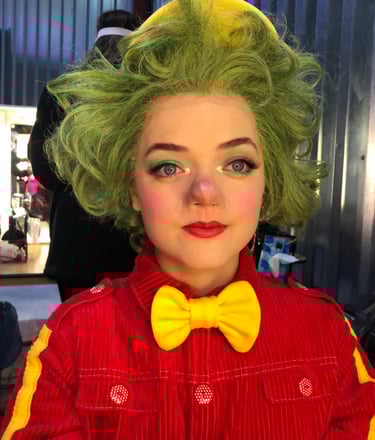 A character from a production displaying theatrical makeup  