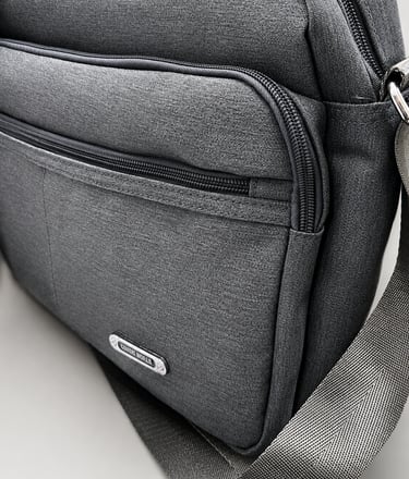 Custom metal label attached to a black fabric bag