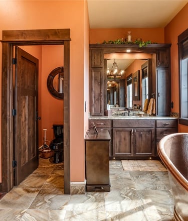 Custom master bathrooom with wood trim and copper clawfoot tub in Arlee