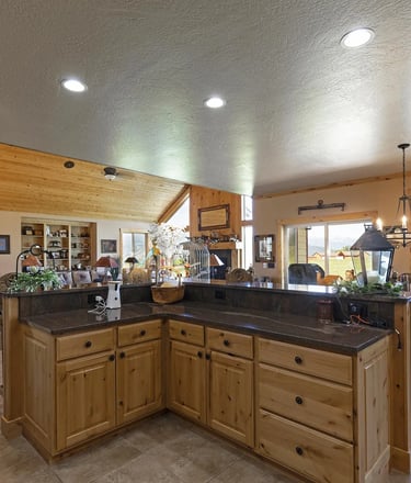 Victor MT custom house/home interior with kitchen island, wood cabinets, and granite countertop