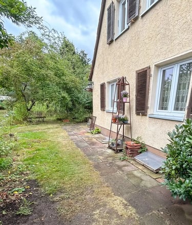 Seitlicher Gartenbereich einer Doppelhaushälfte mit gepflegtem Grün und Terrasse.