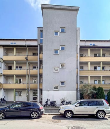 Mehrfamilienhaus in Fürth-Poppenreuth mit mehreren Balkonen und modernem Eingangsbereich.