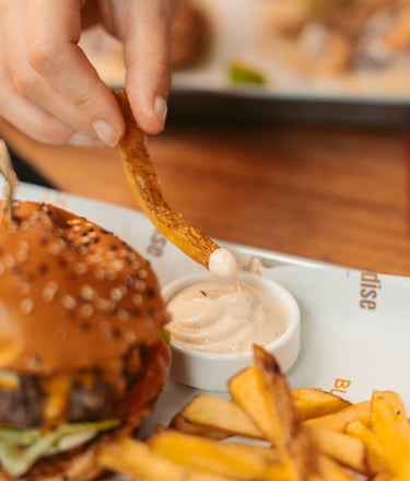 a person is holding a piece of food in front of a hamburger burger king
