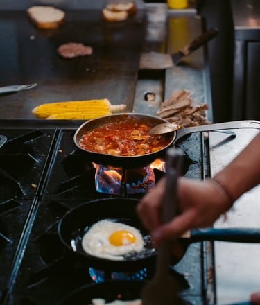 a person cooking food on a stove top