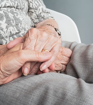 une personne tient la main d'une personne âgée