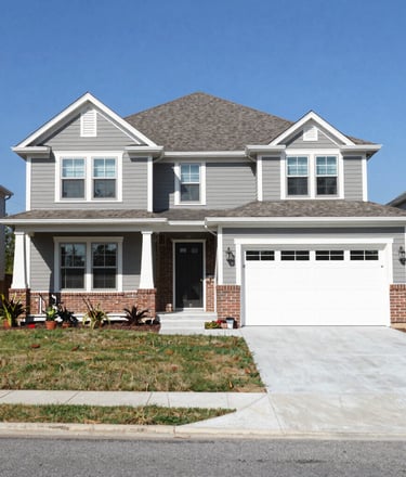 Modern white two-story garage apartment with black trim, double bay doors, and a covered carport.