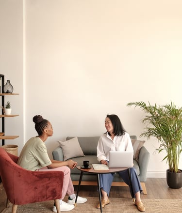 a woman sitting on a couch talking to a woman