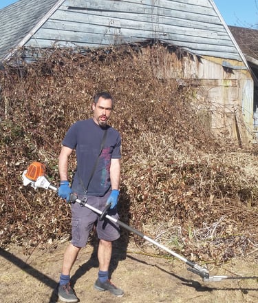 picture of a man holding gas hedge trimmers