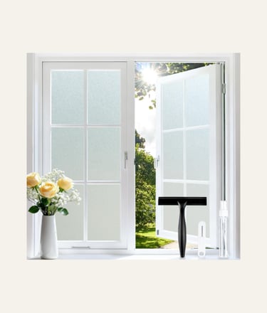 Frosted privacy window film applied to a white casement window with squeegee installation tools.