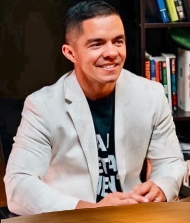 Cody Sechelski smiling in a white jacket, representing transformation from adversity to purpose-driven leadership