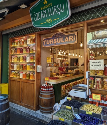 A colorful pickle and olive market in Istanbul with shelves of jars and containers of pickles.