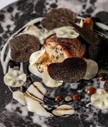 Gourmet dish with black truffles and creamy sauce.