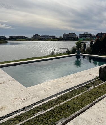 Una piscina con vista a un lago y un barco.