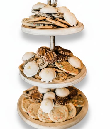 Assorted homemade cookies including iced tea cakes and chocolate chip on a tiered dessert stand