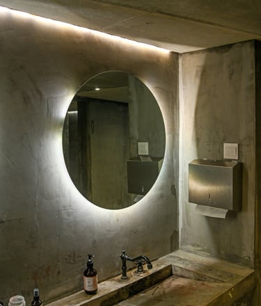 Salle de bain rénovée avec enduit décoratif effet béton ciré et miroir lumineux LED mural