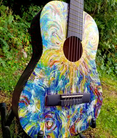 peinture sur guitare aux couleurs vives, avec un soleil autour de la rosace et des formes abstraites