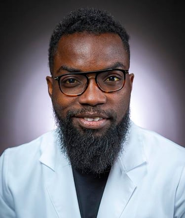 a man with a beard and glasses on a white coat