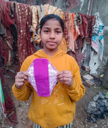 Young girl holding up a Hanaru reusable sanitary napkin