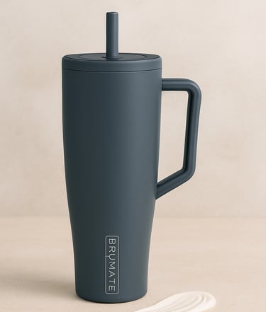 Dark gray tumbler with straw and handle on a neutral background