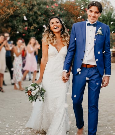 Braut und Bräutigam feiern mit ihren Gästen am Strand
