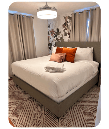 Freshly cleaned Airbnb bedroom with decorative floral wall by SparkEaseCleaning