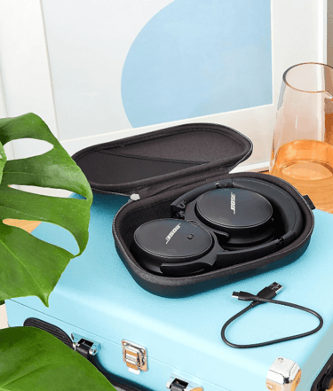 a suitcase case with a pair of headphones and a glass of water